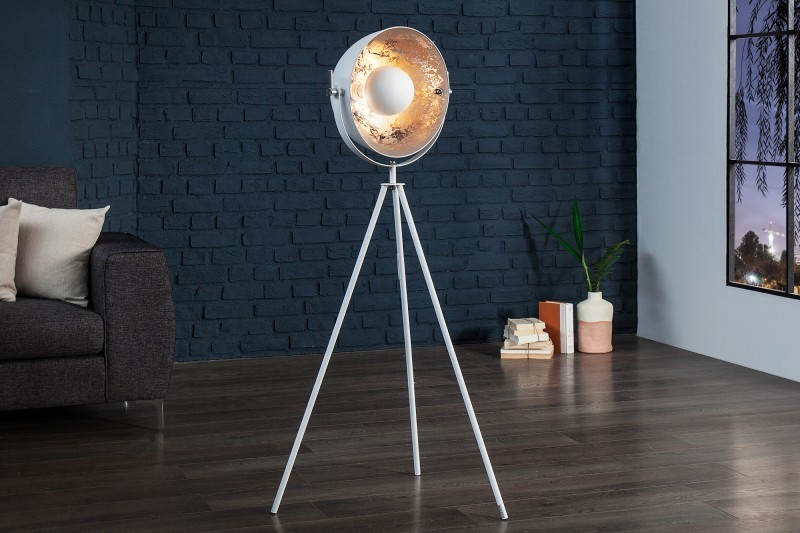 Une lampadaire trepied design en acier inoxydable et en aluminium coloris blanc et argenté