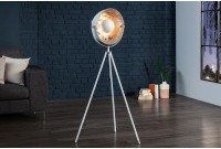 Une lampadaire trepied design en acier inoxydable et en aluminium coloris blanc et argenté